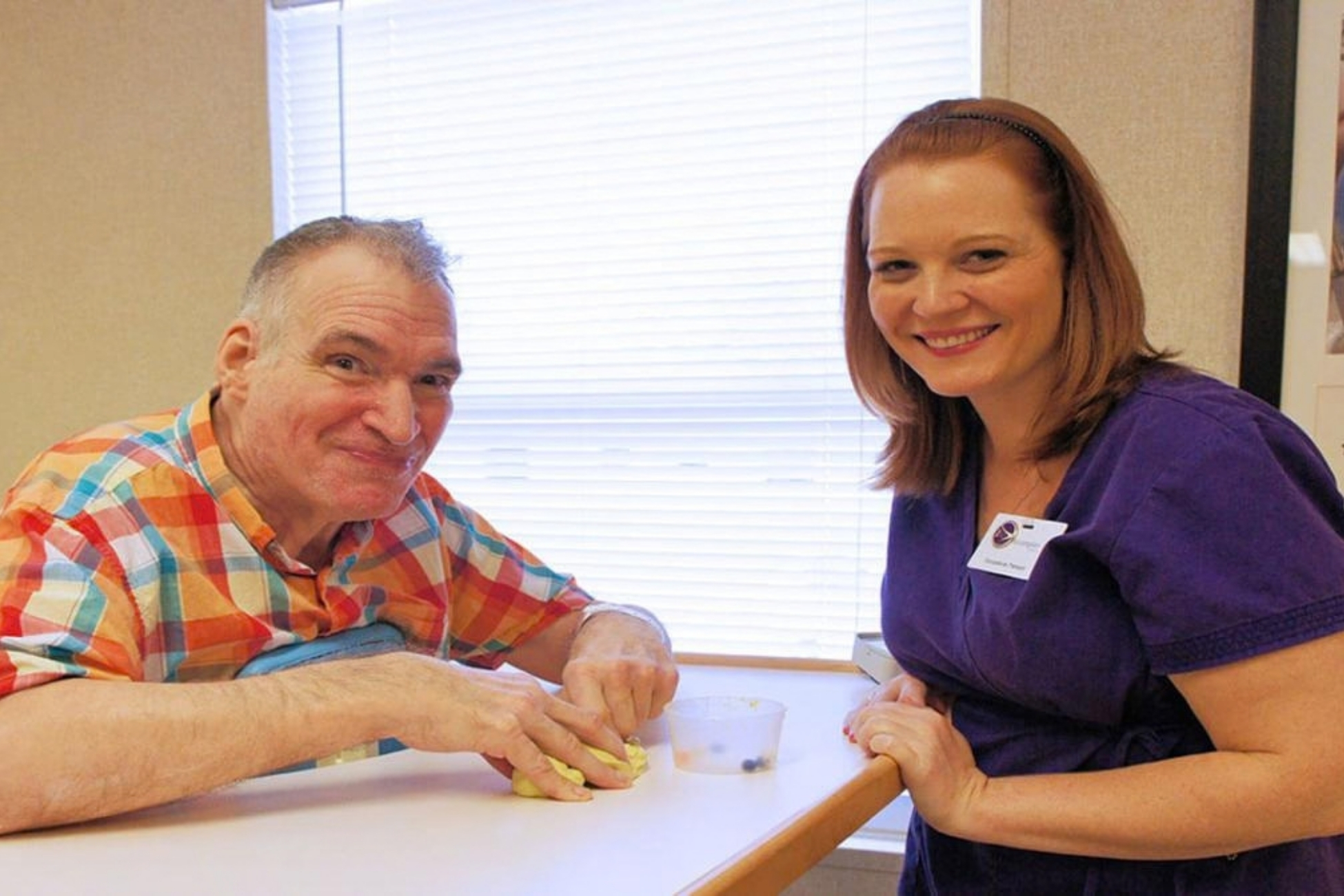 Caregiver supports a resident during mealtime.