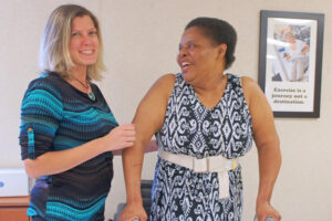 Therapist supports a resident during a rehabilitation session.