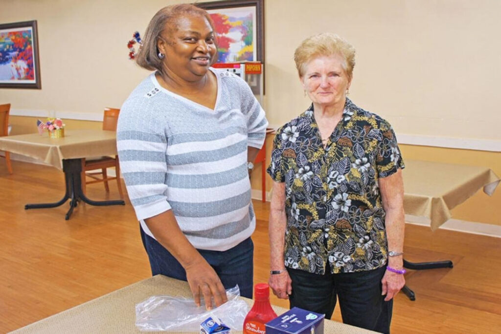 Staff member and resident participate in an indoor activity.