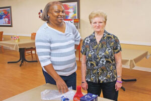 Staff member and resident participate in an indoor activity.