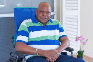 Resident relaxes in a chair on the outdoor patio.