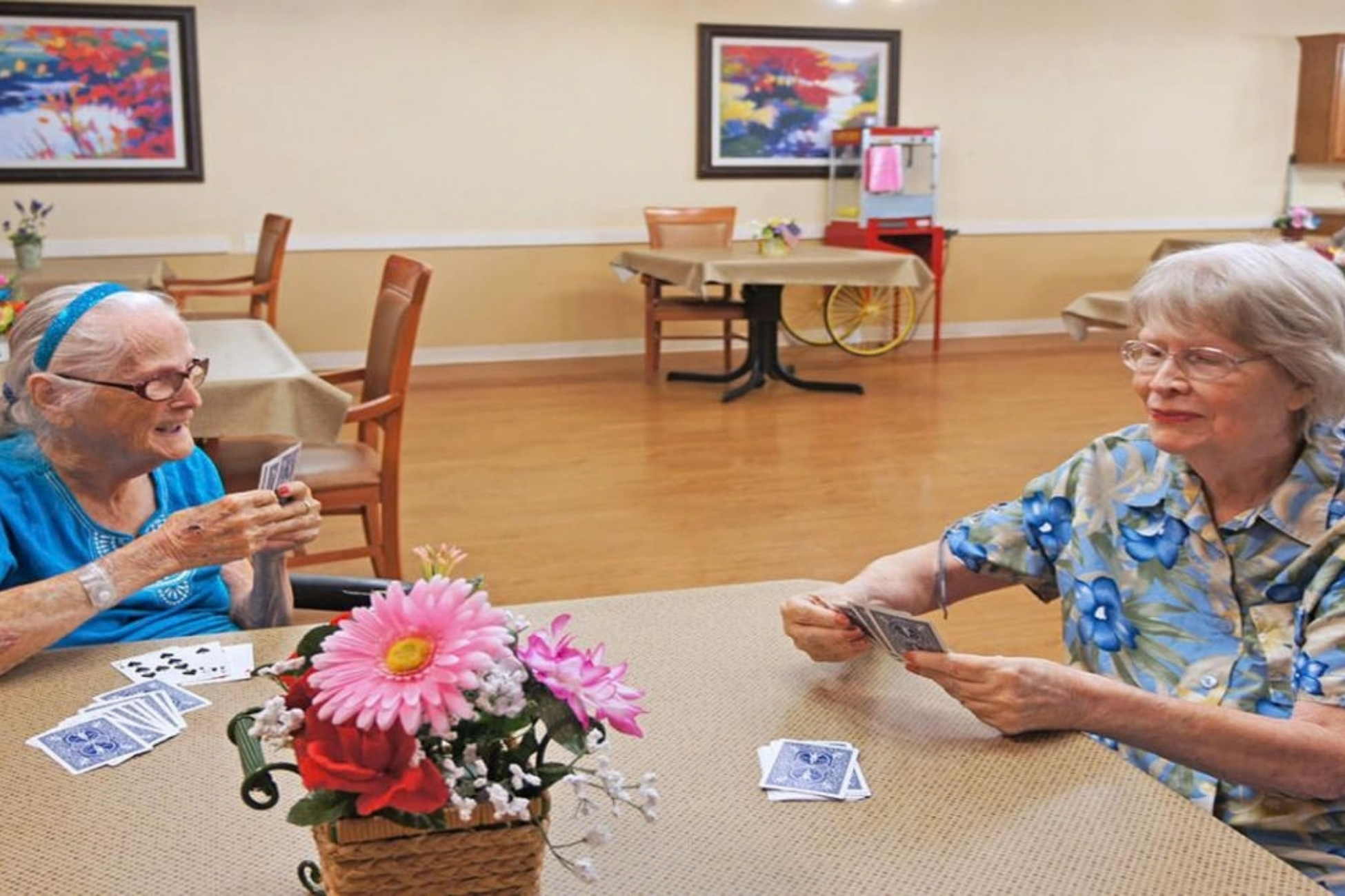 PACS-300x200-activity2 Two residents play cards together in the dining room.